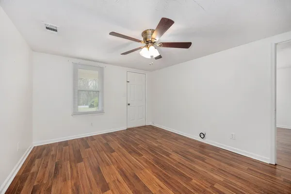 wooden floor in an empty room with a window