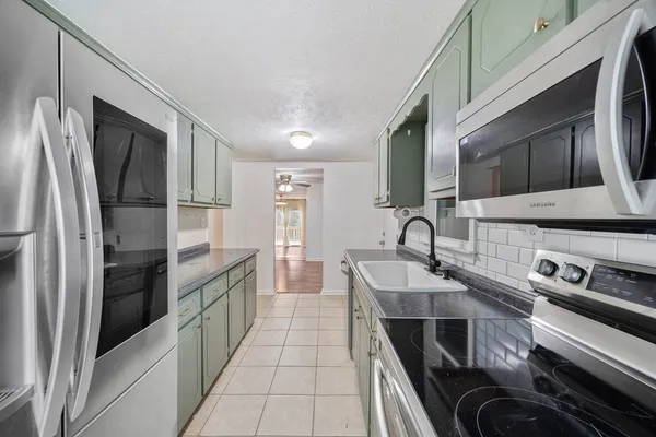 a kitchen with stainless steel appliances granite countertop a refrigerator and a stove