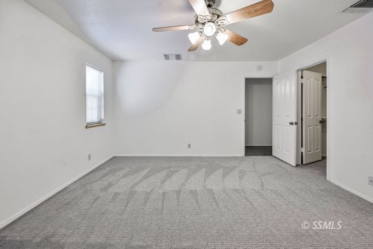 1213 Alysa Court Ridgecrest, CA 93555 - Photo 23 of 34 an empty room with chandelier fan and windows