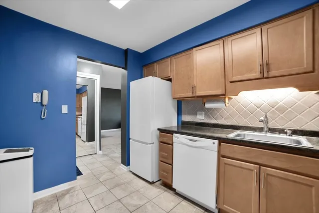a kitchen with granite countertop white cabinets and stainless steel appliances
