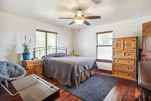 a spacious bedroom with a bed and wooden floor
