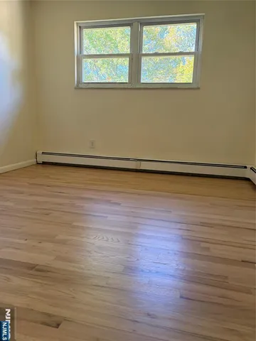 a view of a room with wooden floor and a window