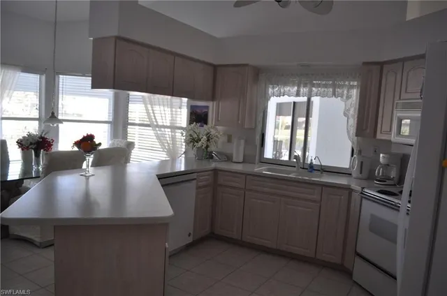 a kitchen with kitchen island granite countertop a sink stove and refrigerator