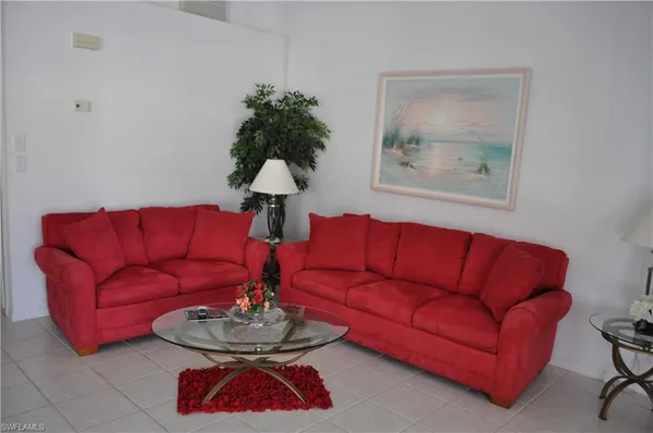 a living room with furniture a couch and a lamp