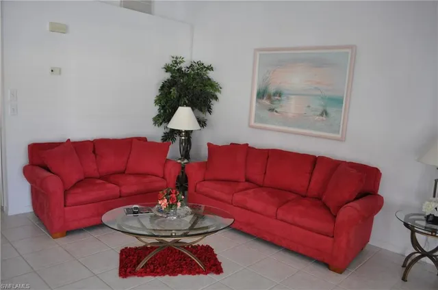 a living room with furniture a couch and a lamp