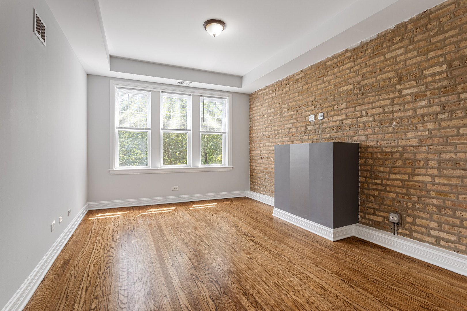 7326 North Damen Avenue, Unit 3 Chicago, IL 60645 - Photo 2 of 14 a view of an empty room with wooden floor and a window