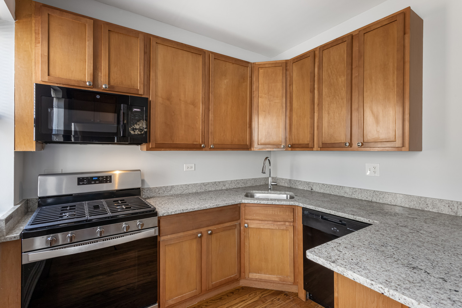 7326 North Damen Avenue, Unit 3 Chicago, IL 60645 - Photo 5 of 14 a kitchen with stainless steel appliances granite countertop a sink a stove a microwave and cabinets