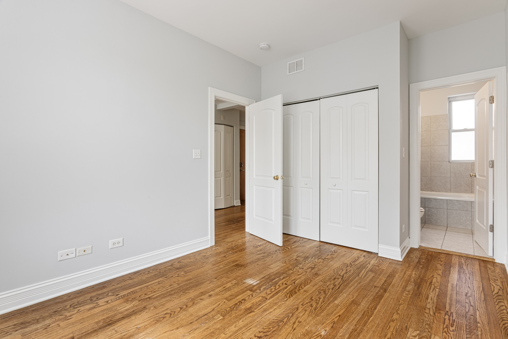 7326 North Damen Avenue, Unit 3 Chicago, IL 60645 - Photo 6 of 14 a view of an empty room with wooden floor and a window