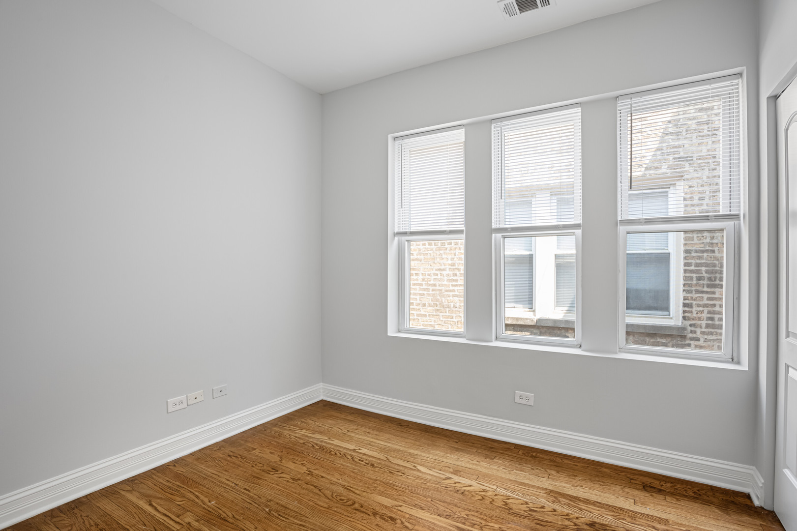 7326 North Damen Avenue, Unit 3 Chicago, IL 60645 - Photo 7 of 14 a view of an empty room with wooden floor and a window
