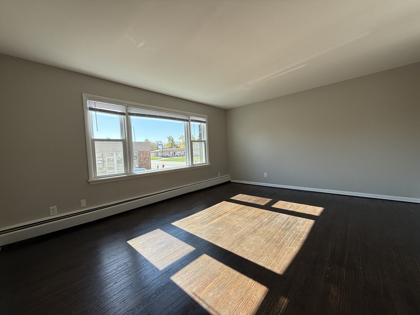 17909 Torrence Avenue, Unit 3 Lansing, IL 60438 - Photo 2 of 9 an empty room with wooden floor and windows