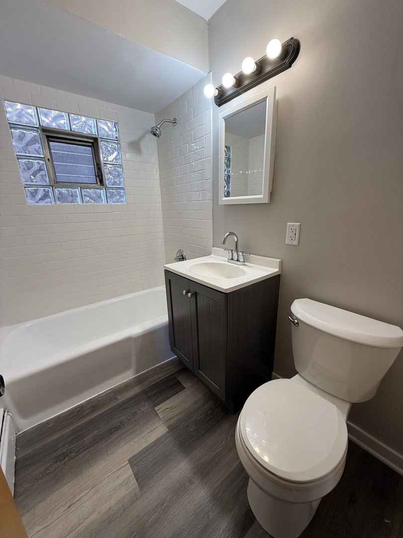 17909 Torrence Avenue, Unit 3 Lansing, IL 60438 - Photo 8 of 9 a bathroom with a toilet a sink and mirror