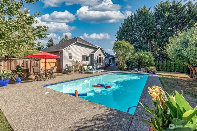 a view of a house with swimming pool and sitting area