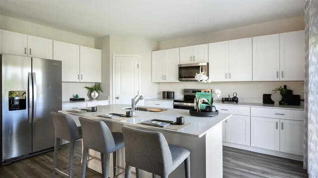 a kitchen with a stove a sink a microwave and refrigerator