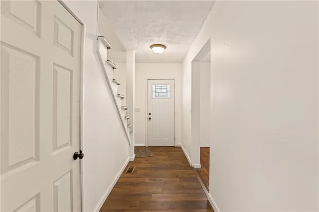 a view of a hallway with wooden floor and staircase