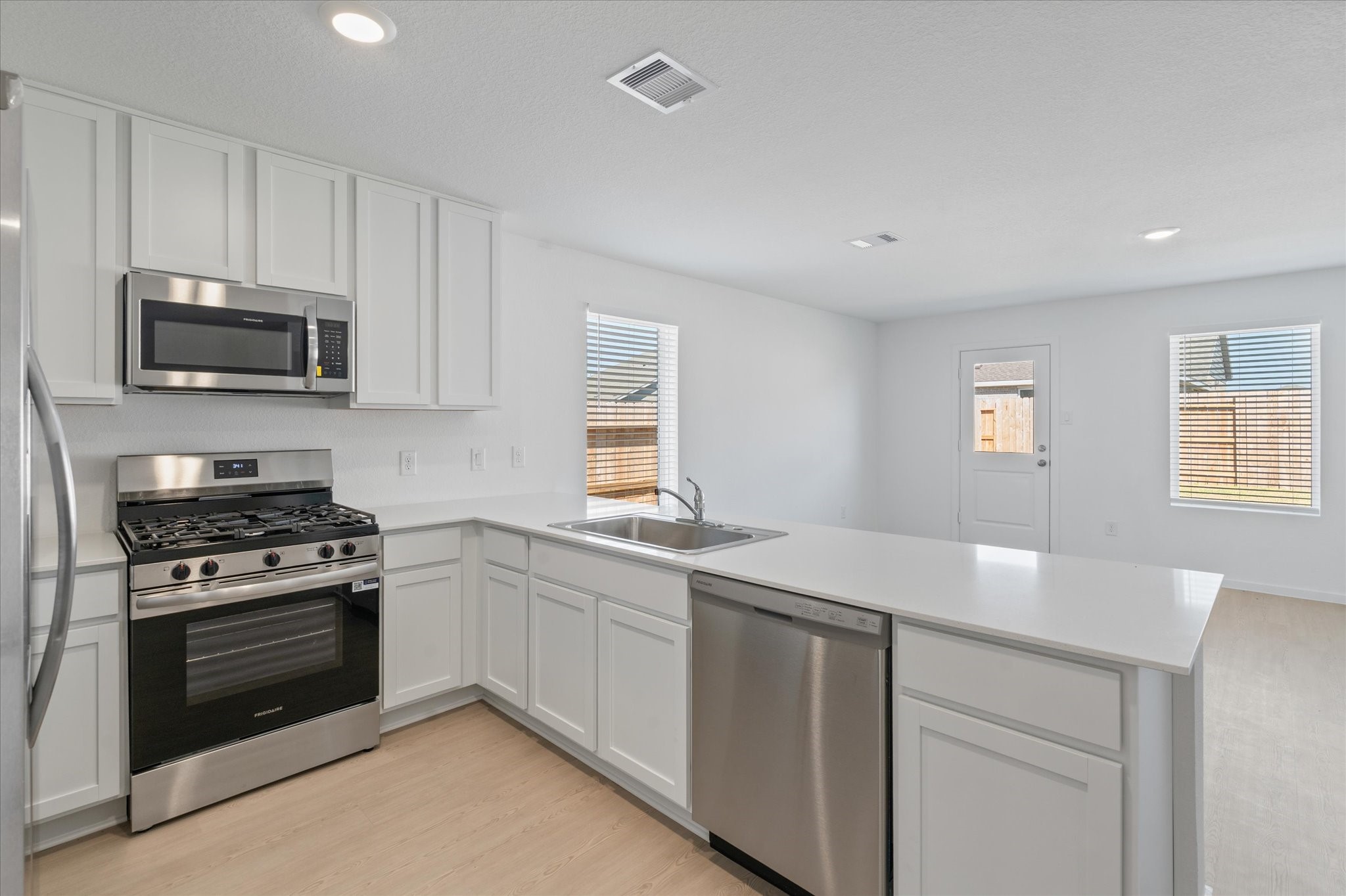 28922 Rustic Windmill Way Hockley, TX 77447 - Photo 13 of 24 a kitchen with granite countertop white cabinets and stainless steel appliances
