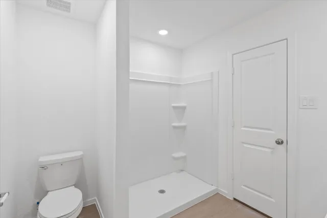 a bathroom with a shower a toilet and a sink