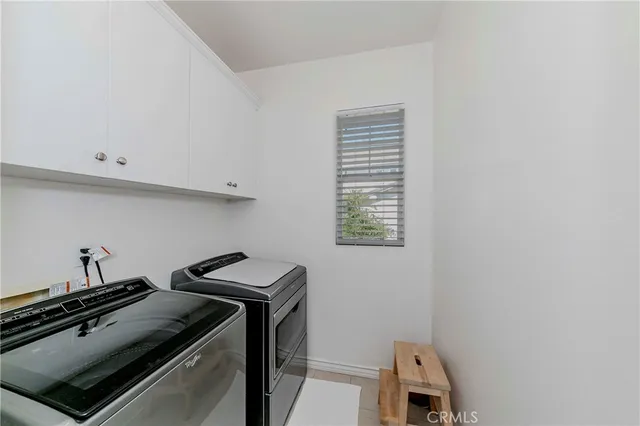 a front view of a house with a yard and potted plants