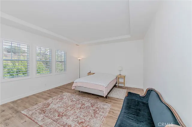 a bedroom with a bed a desk and chair with window