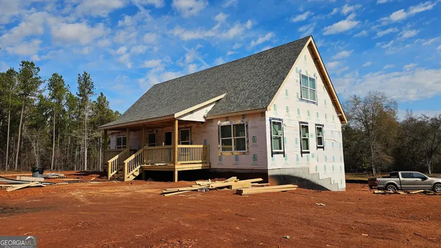 a view of a blue house with outdoor space and covered with trees
