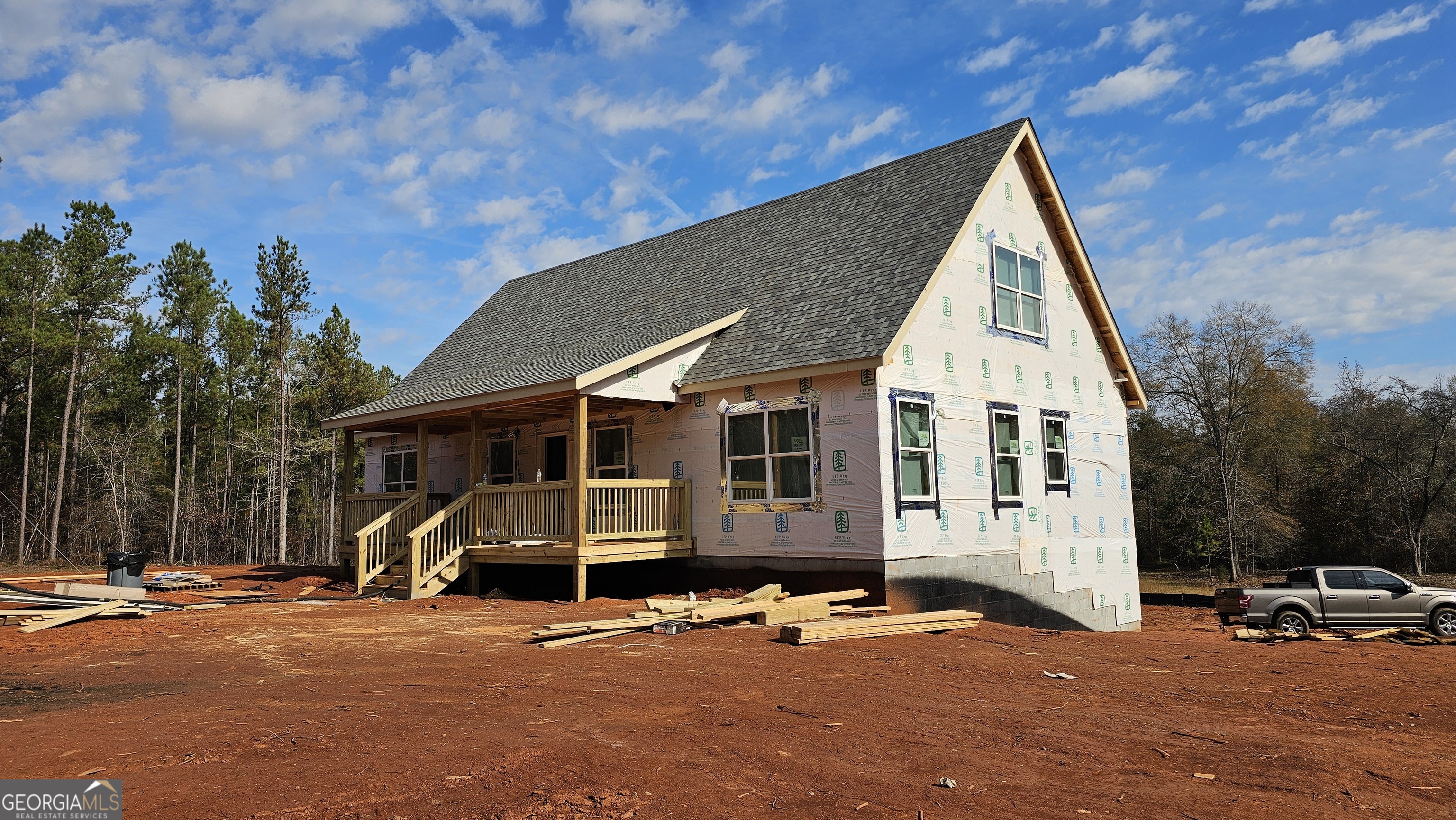 a view of a blue house with outdoor space and covered with trees