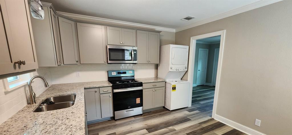 205 Roy Street Minden, LA 71055 - Photo 3 of 8 a kitchen with stainless steel appliances a stove a sink a refrigerator a window a counter space and cabinets