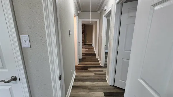 a view of a hallway with wooden floor and entryway