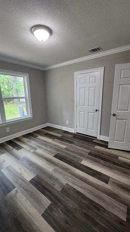 205 Roy Street Minden, LA 71055 - Photo 6 of 8 an empty room with wooden floor and windows