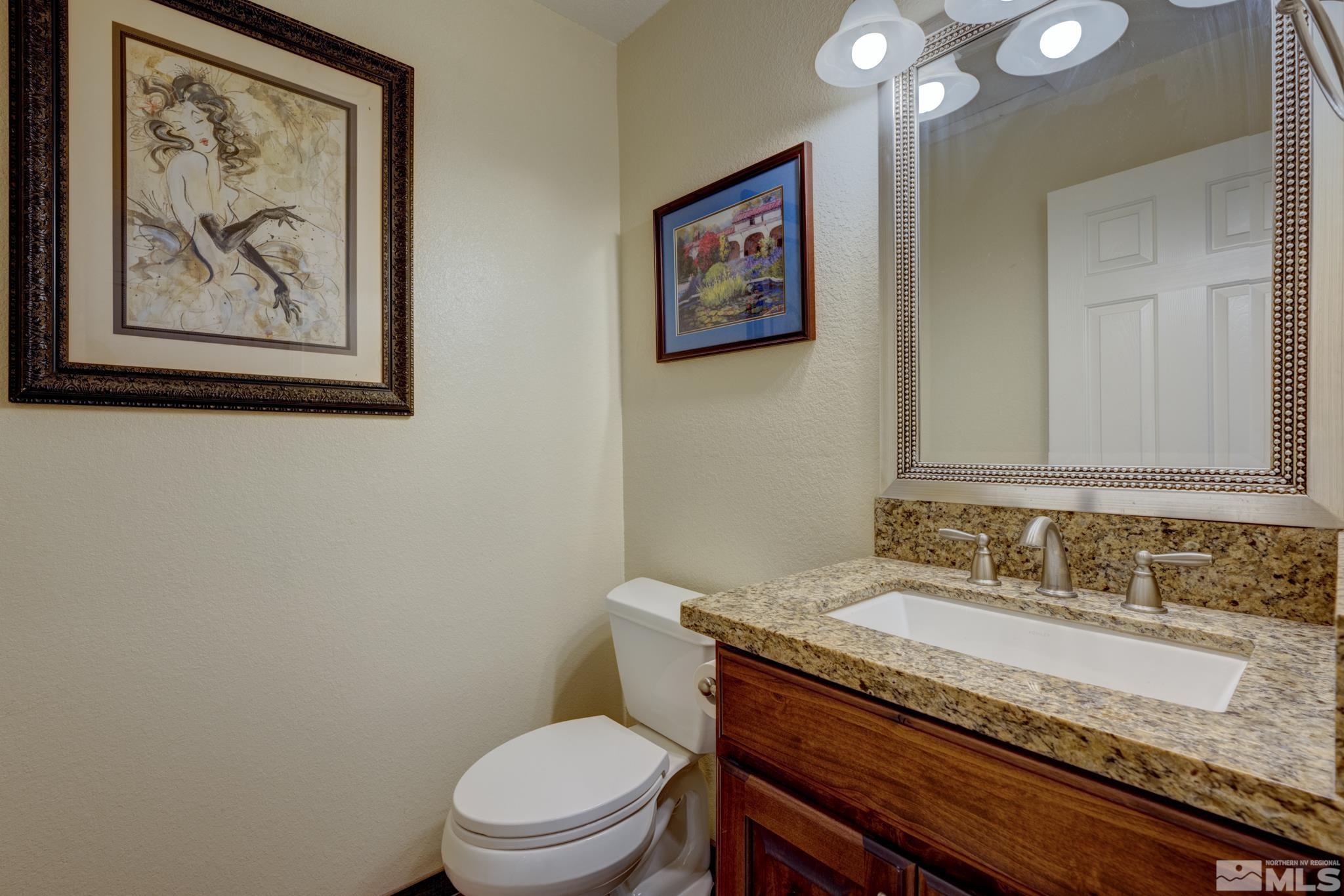 3760 Paradise View Carson City, NV 89703 - Photo 30 of 40 a bathroom with a granite countertop toilet a sink and mirror
