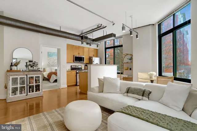 a living room with furniture a flat screen tv and a window