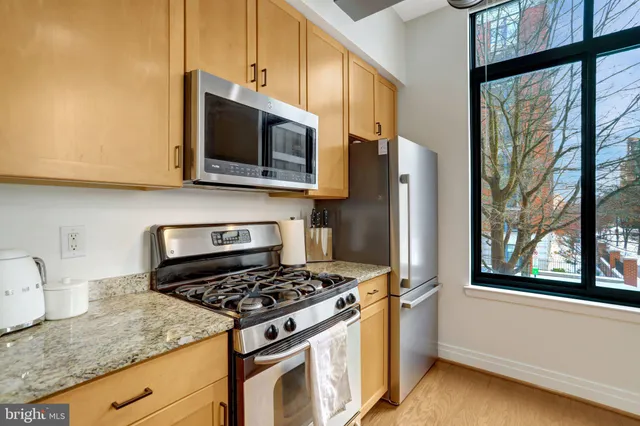 a kitchen with stainless steel appliances granite countertop a stove a microwave and a sink