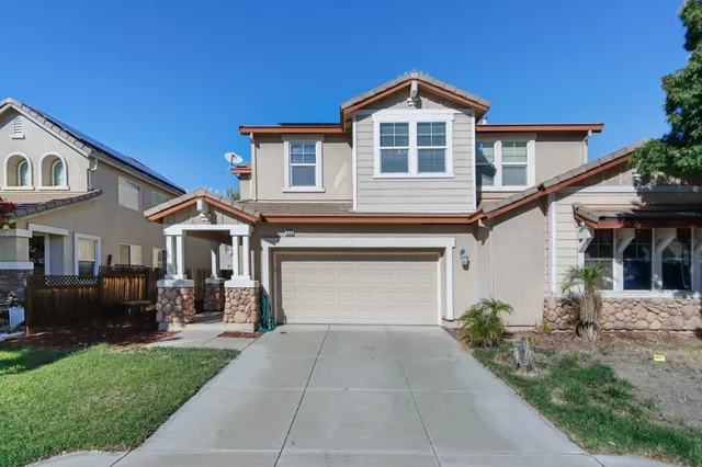 a front view of a house with a garden and patio