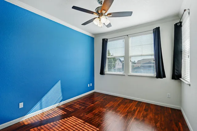 a view of a room with wooden floor and fan