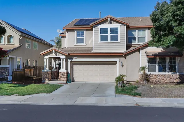 a front view of a house with a yard and garage