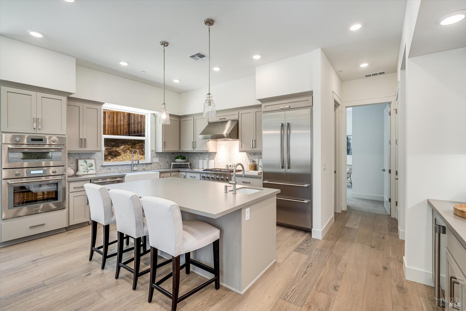 107 Grace Lane Napa, CA 94559 - Photo 12 of 39 a kitchen with kitchen island wooden floors white appliances and cabinets