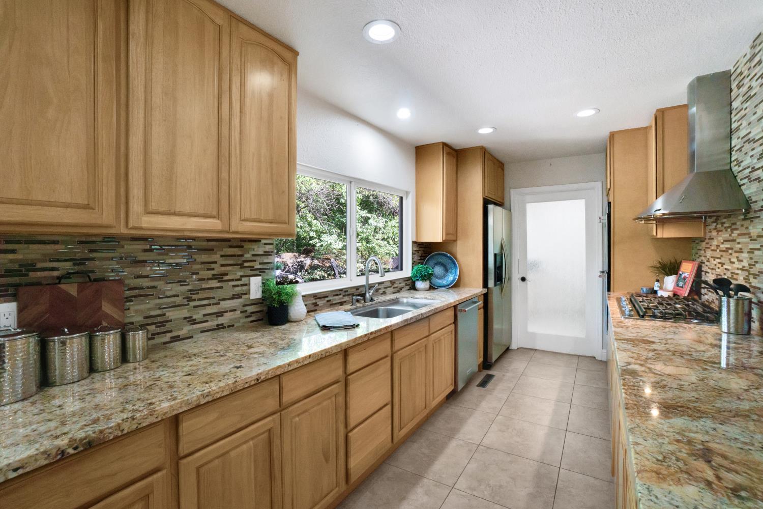 6299 Horseshoe Bar Road Loomis, CA 95650 - Photo 8 of 43 a large kitchen with stainless steel appliances granite countertop a lot of counter space and a sink