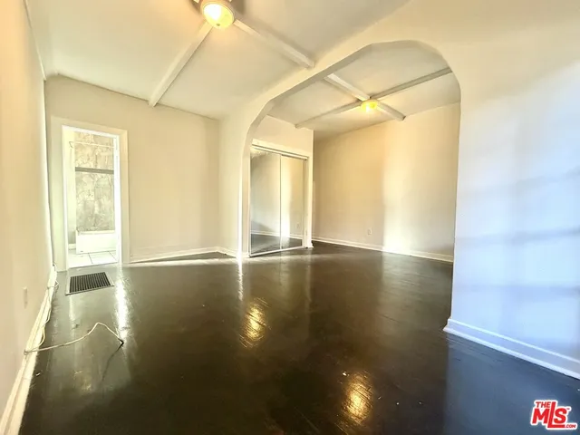 a view of empty room with wooden floor