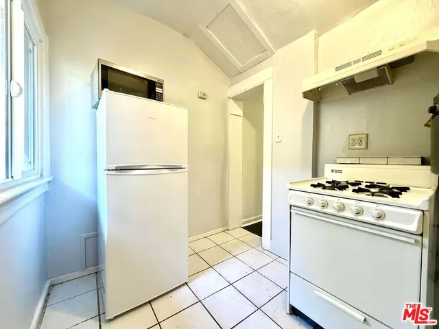 a kitchen with a stove a refrigerator and a window