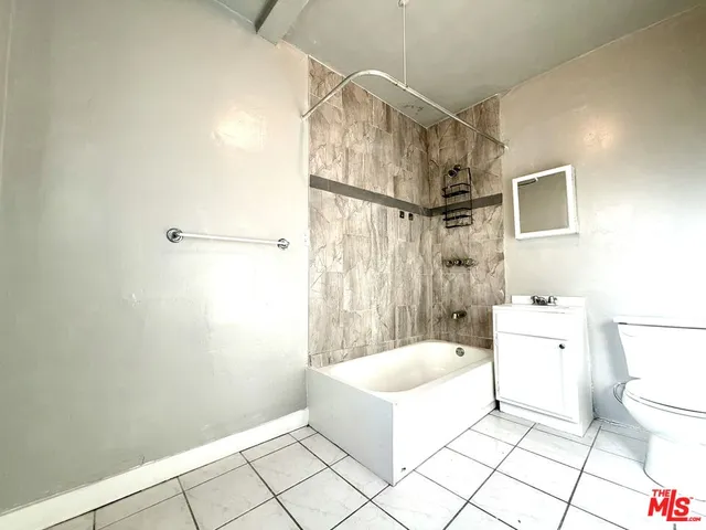 a bathroom with a tub a toilet and a shower