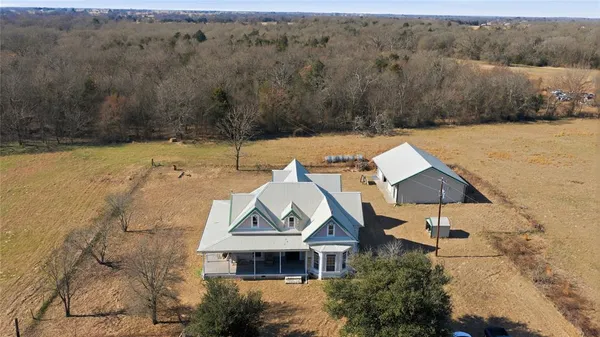 an aerial view of a house with a garden and lake view