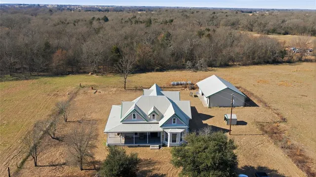 an aerial view of a house with a garden and lake view