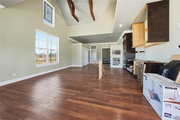 a view of a living room and kitchen with furniture wooden floor and windows