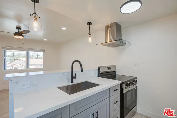 a kitchen with stainless steel appliances a sink a stove and a window