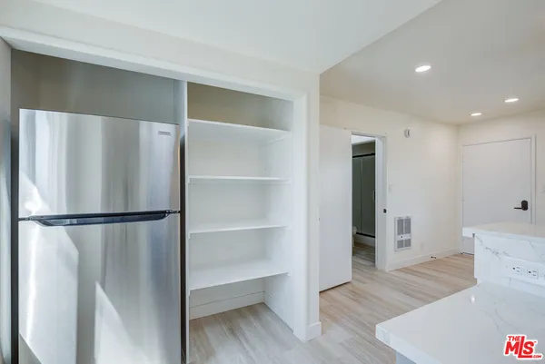a white refrigerator freezer and a wooden floor