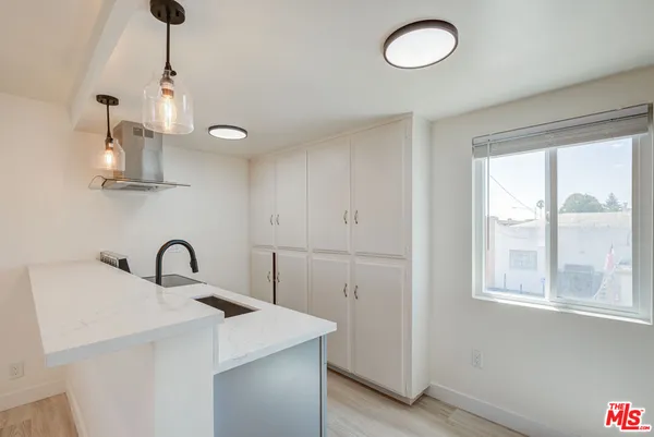 a kitchen with cabinets and chandelier