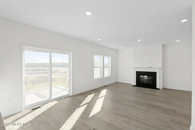 a view of an empty room with a window and fireplace