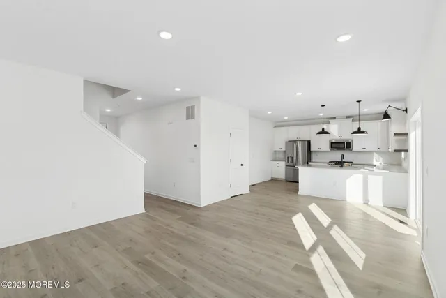 a view of kitchen with kitchen island white cabinets and refrigerator
