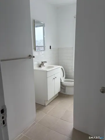 a spacious bathroom with a toilet sink and mirror
