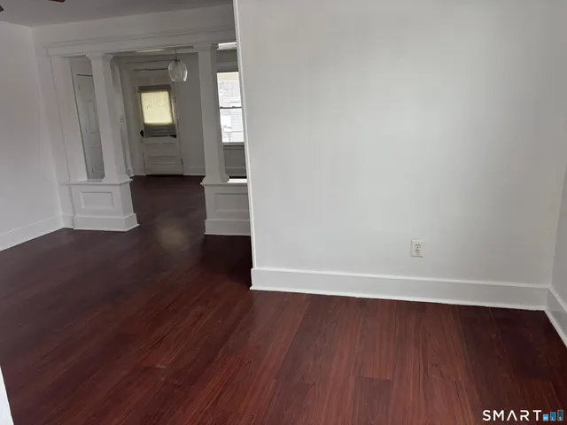 a view of a room with wooden floor and a window