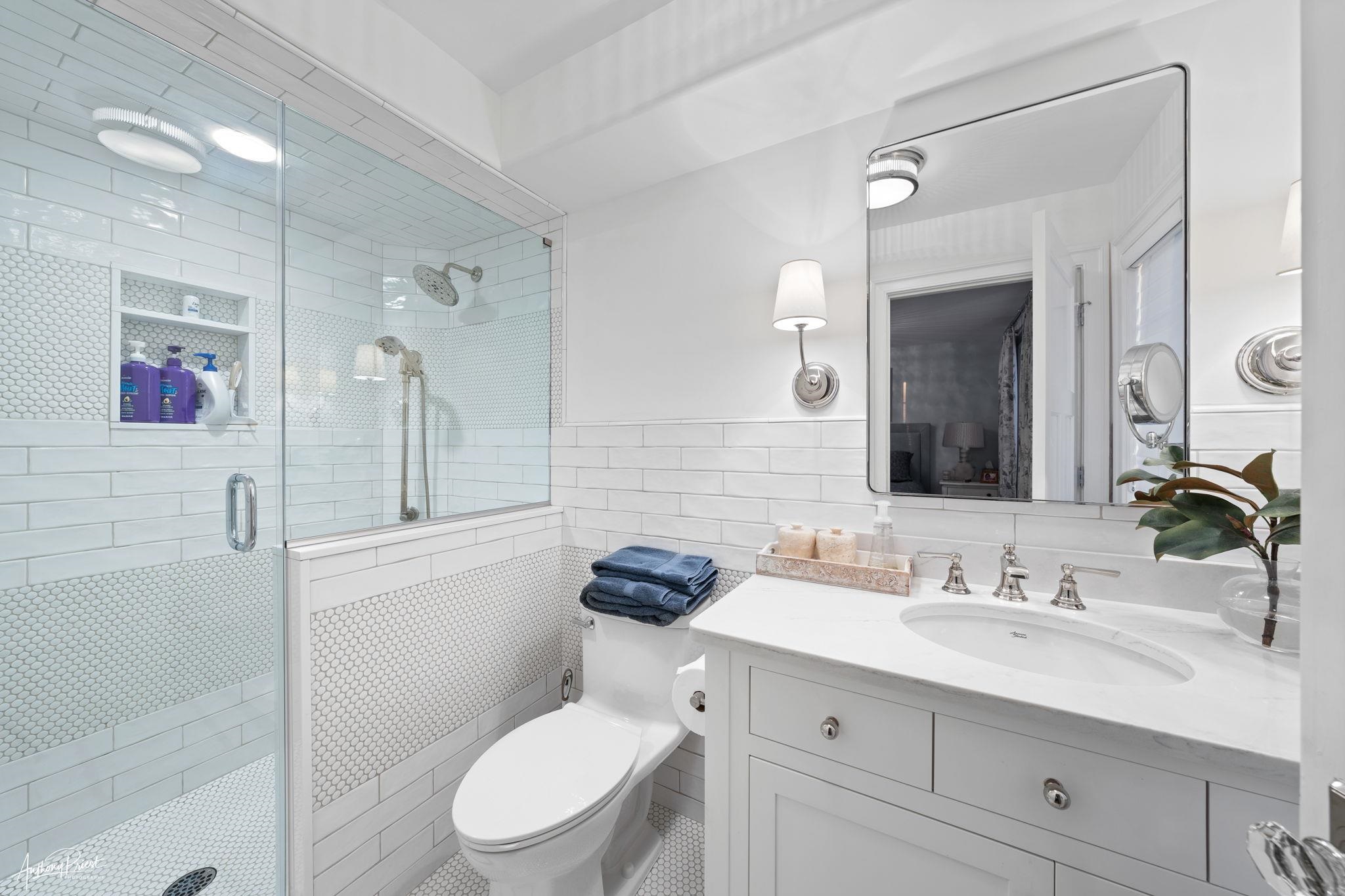 526 7th Street Avalon, NJ 08202 - Photo 21 of 24 a bathroom with a granite countertop toilet sink double vanity and mirror