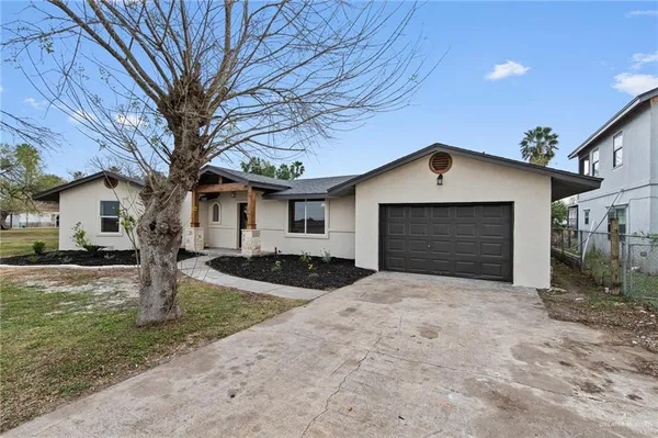 a front view of a house with yard and parking space